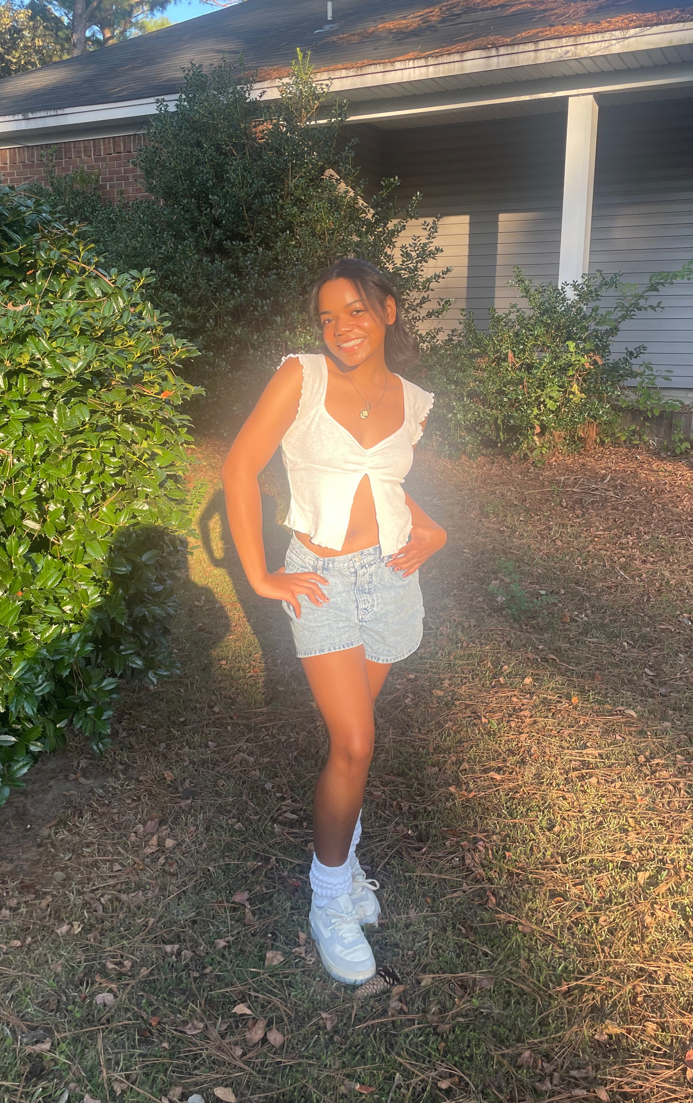 Kameron Burns smiles, with a house and tree in the background