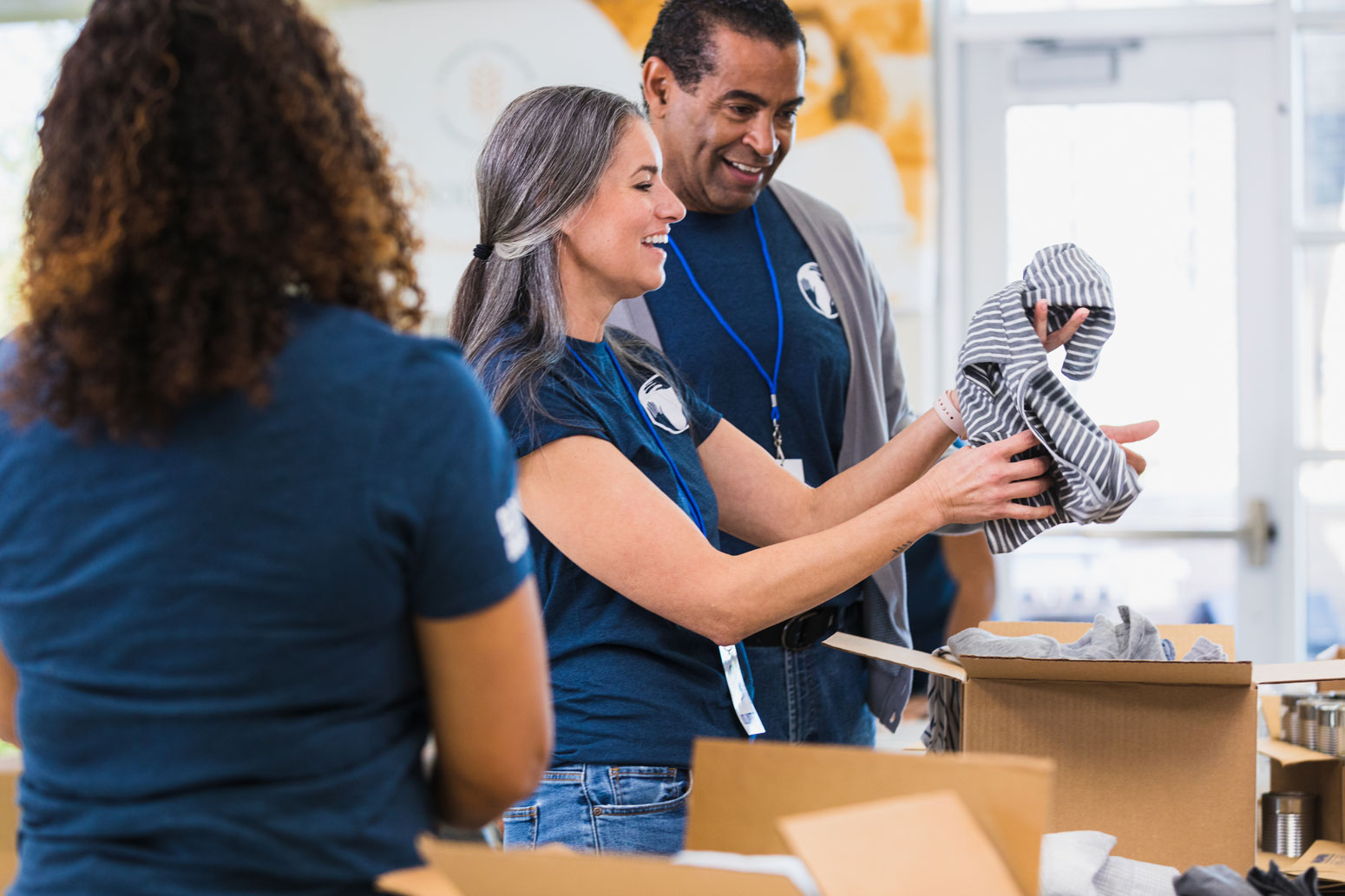 Nonprofit volunteers sorting clothing donations for community distribution at a donation center.
