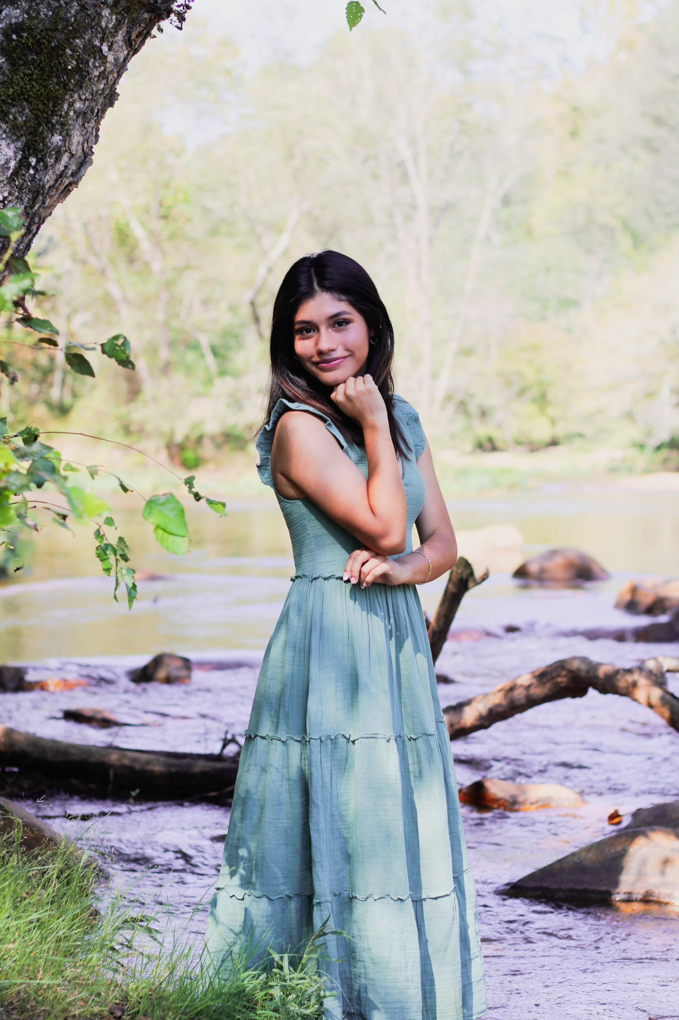 Laura standing next to a tree and in front of a river.