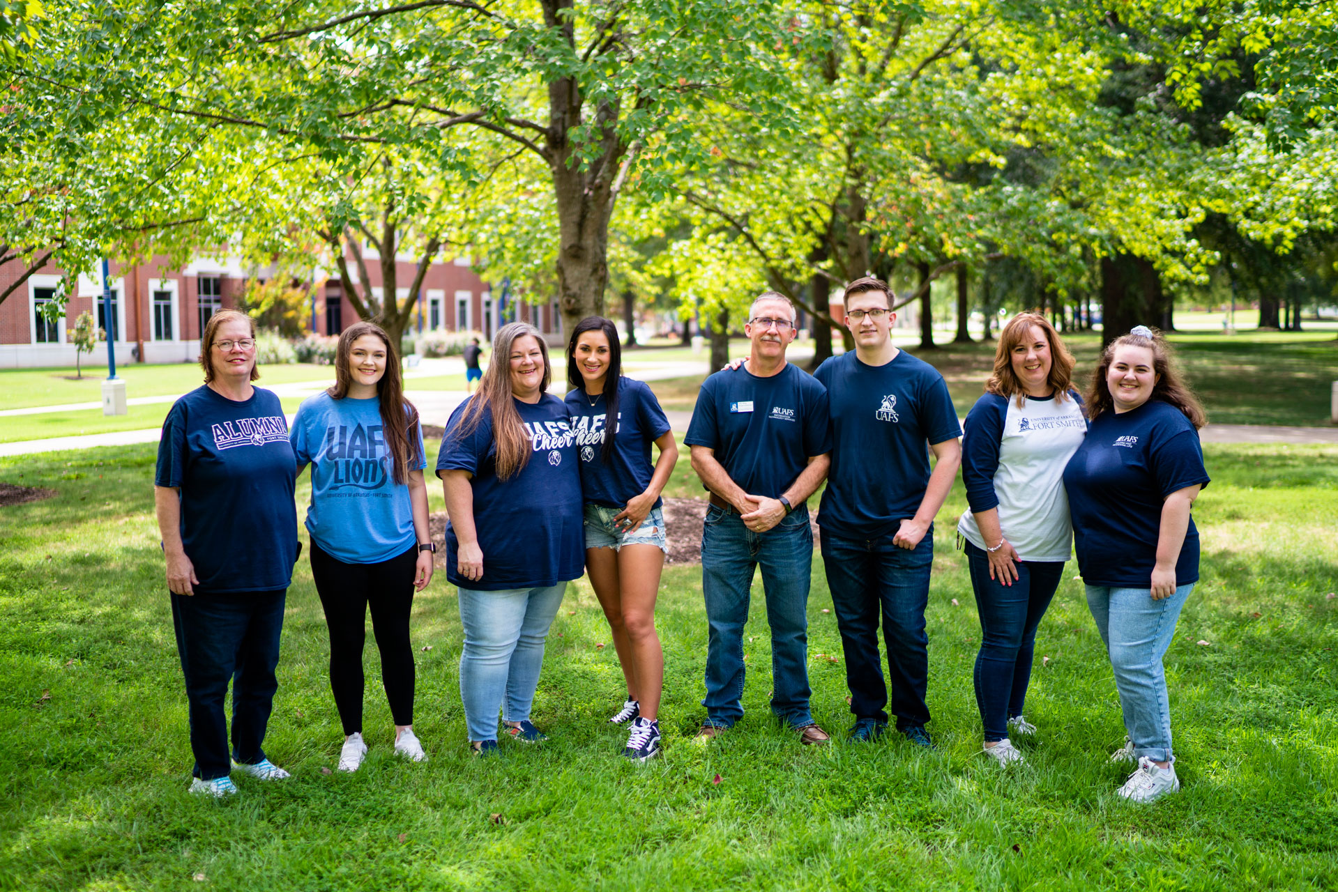 Four students stand with family members on the UAFS campus.