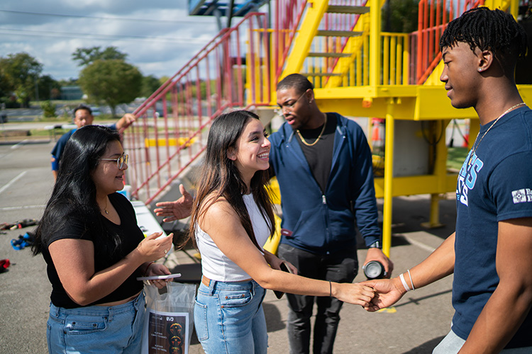 students speaking with one another on the UAFS campus.