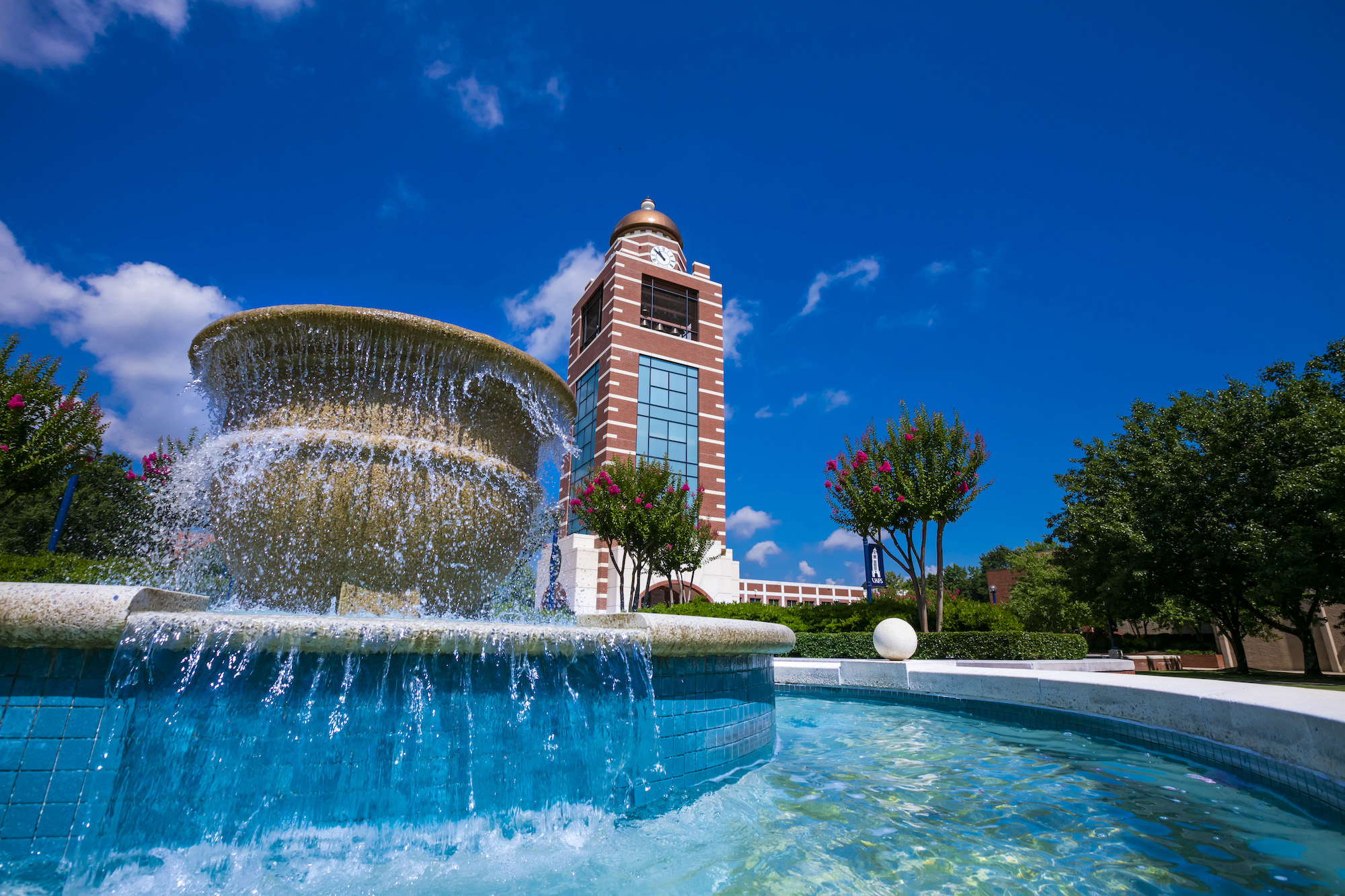 UAFS Bell Tower seen behind a fountain on the campus green