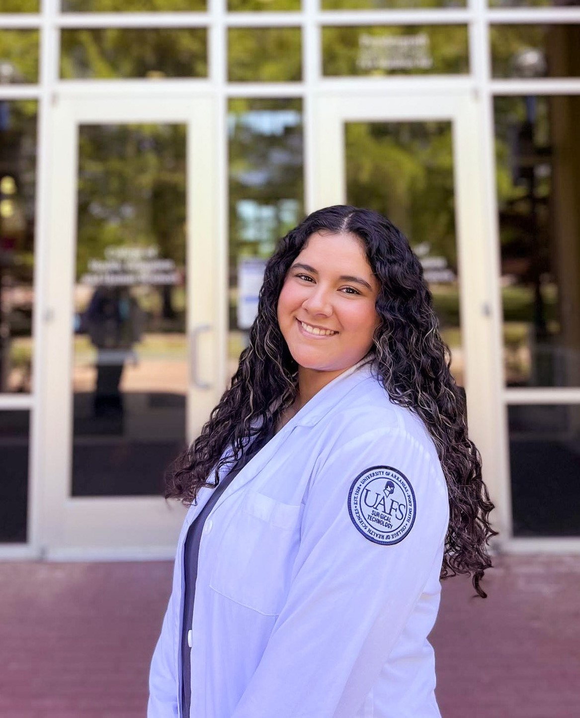 Woman in lab coat outside