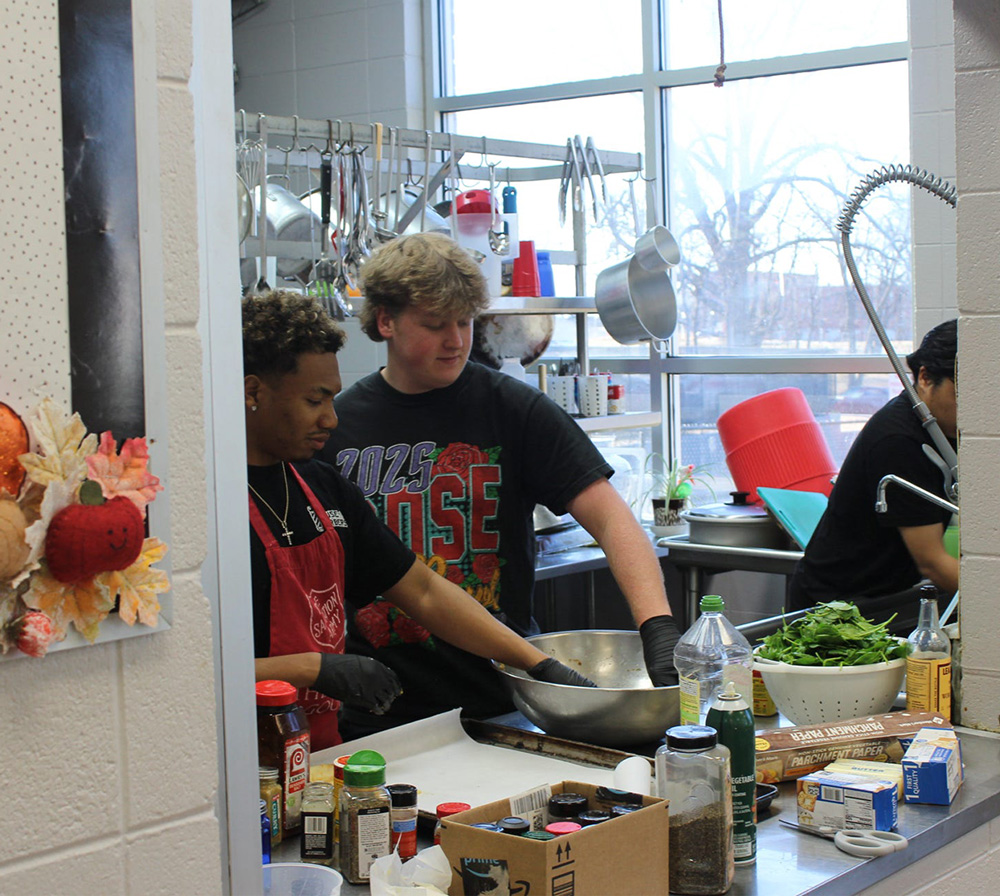 Parker Reed, right, and UAFS alum Joseph Jones Jr. prepare a salad while volunteering at the Salvation Army of Fort Smith.