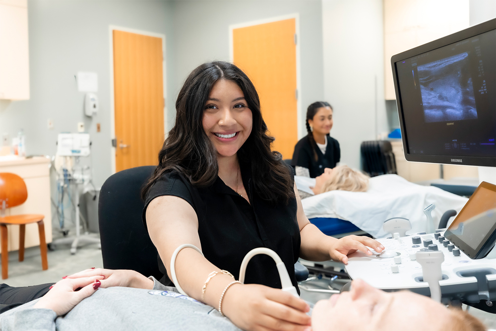 Lesly Nájera smiles while looking over a patient.