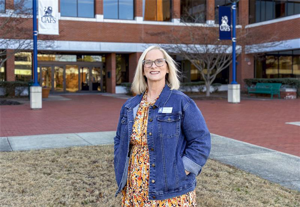 Tracie Griffith, administrative specialist for mathematics, stands in front of the UAFS Math Science Building