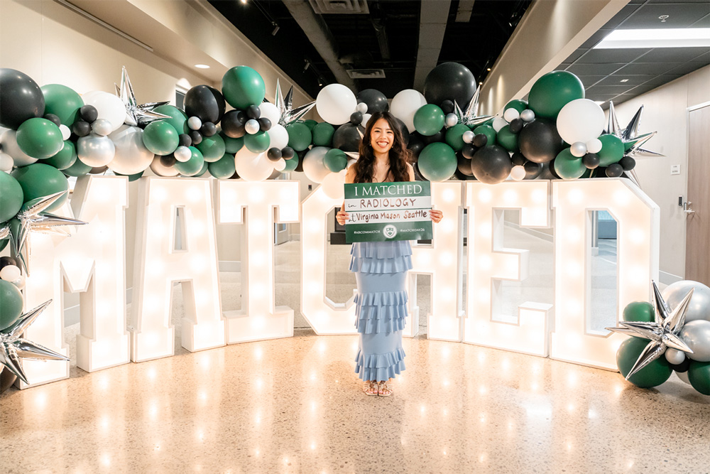 UAFS alum, Vi Le, '19, holds a sign saying she matched with radiology at Virginia Mason Seattle
